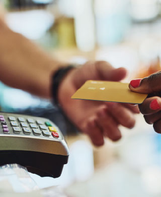 Woman handing credit card to make payment.