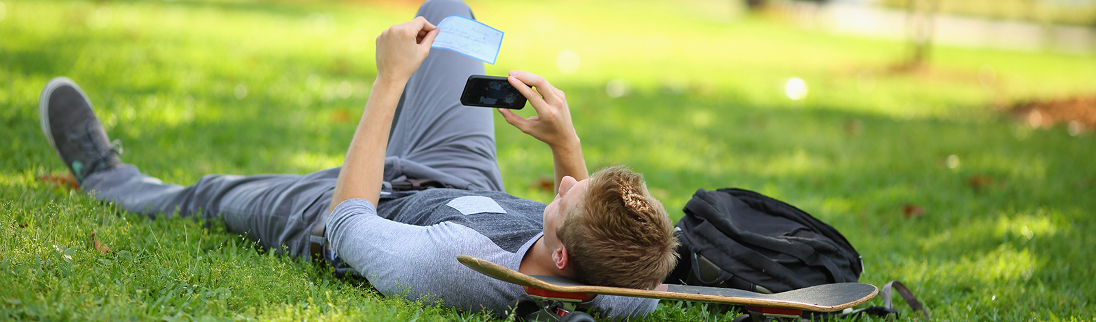 young man in park mobile deposit