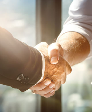 Close up of two men shaking hands.